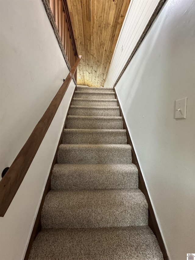 stairway with carpet and wooden ceiling