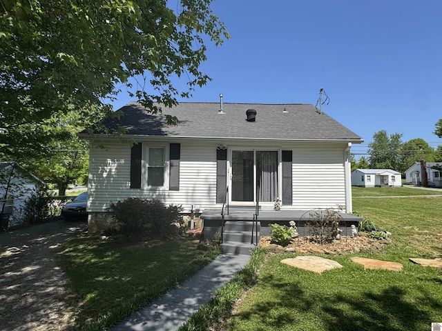 view of front of house featuring roof with shingles and a front lawn
