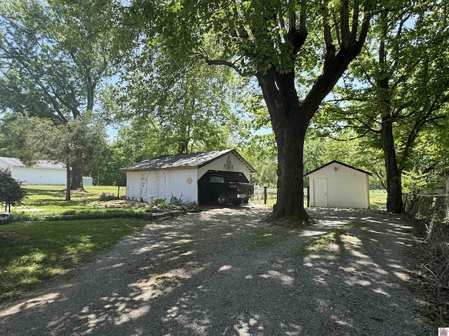 garage featuring a storage shed and driveway
