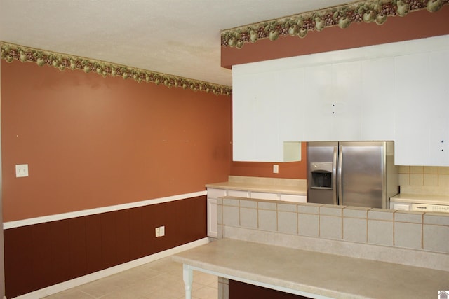 1725 Evelyn Dr, Paducah, KY 42003 - kitchen featuring stainless steel fridge with ice dispenser, white cabinetry, light countertops, tasteful backsplash, and a wainscoted wall