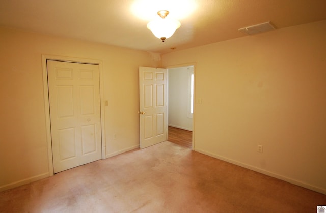unfurnished bedroom with carpet flooring, baseboards, and visible vents