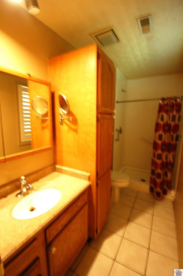 bathroom featuring tile patterned flooring, visible vents, vanity, toilet, and a stall shower