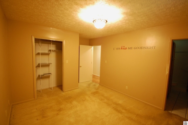 unfurnished bedroom featuring a closet, carpet flooring, and a textured ceiling