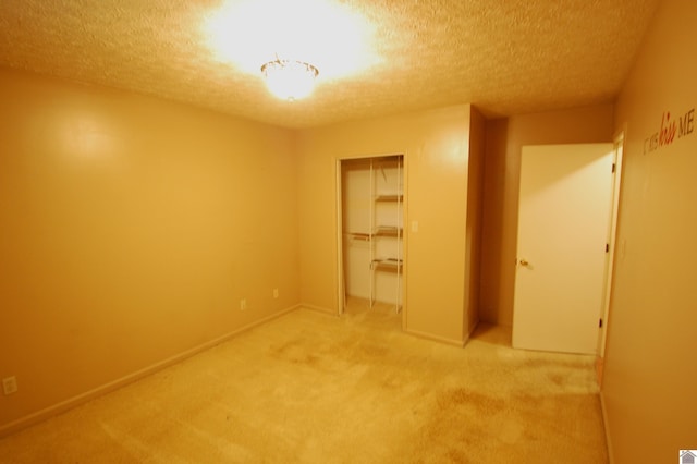 unfurnished bedroom featuring a textured ceiling, light colored carpet, and a closet