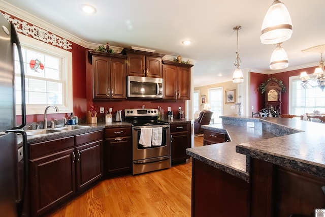 kitchen featuring a sink, dark countertops, stainless steel appliances, and a wealth of natural light