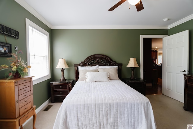 bedroom with light carpet, a ceiling fan, baseboards, visible vents, and ornamental molding