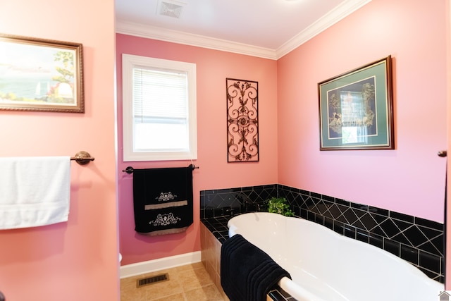 bathroom featuring visible vents, a freestanding tub, crown molding, and baseboards