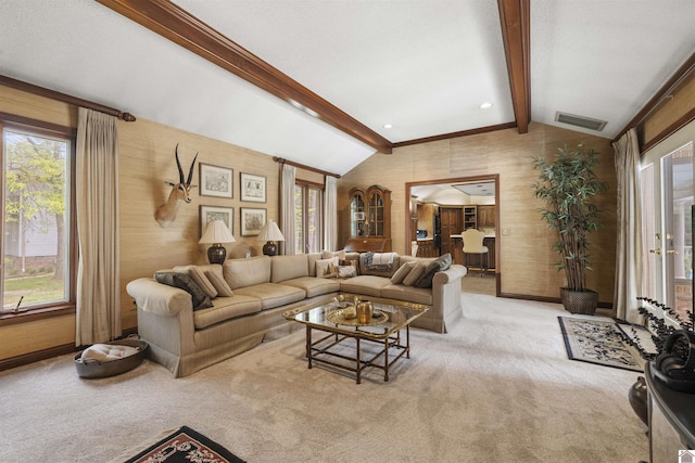 living area featuring carpet flooring, visible vents, plenty of natural light, and vaulted ceiling with beams