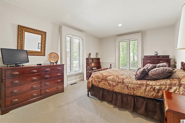 bedroom with a textured ceiling, light colored carpet, and ornamental molding