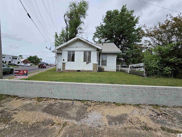 bungalow-style home with fence and a front yard