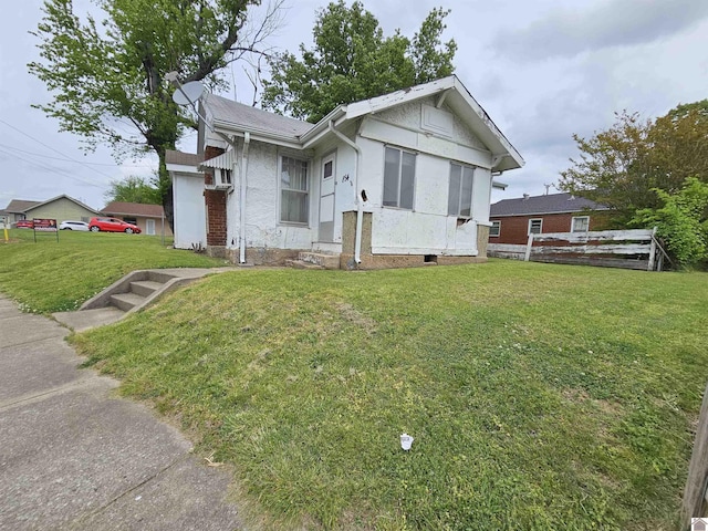 view of front of property featuring fence, stucco siding, and a front lawn