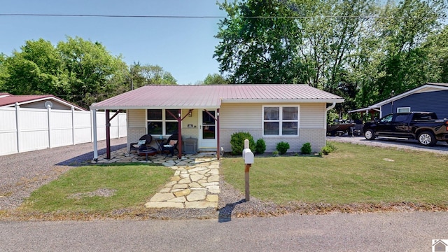 view of front facade with fence, a porch, a front lawn, and brick siding
