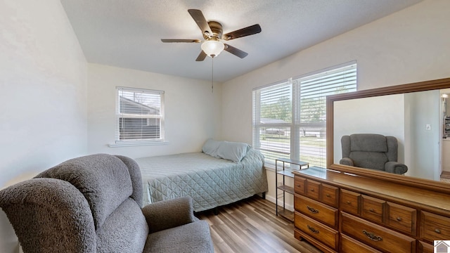 bedroom with light wood-style flooring, ceiling fan, and multiple windows