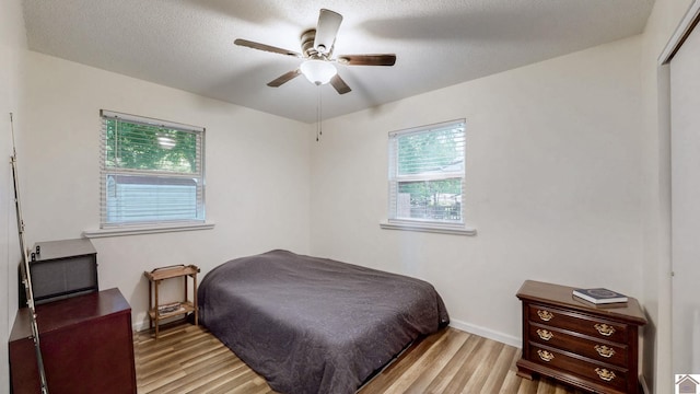 bedroom with baseboards, ceiling fan, and light wood-type flooring