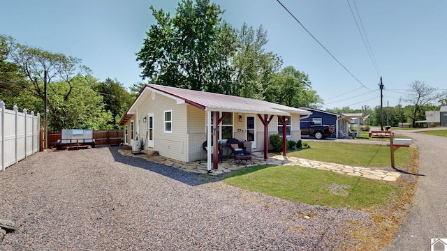 bungalow-style home with brick siding, fence, a front yard, and metal roof