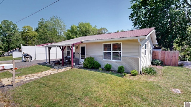 ranch-style home featuring fence and a front lawn
