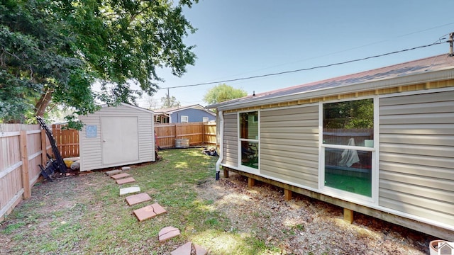 view of yard with an outbuilding, a fenced backyard, and a shed