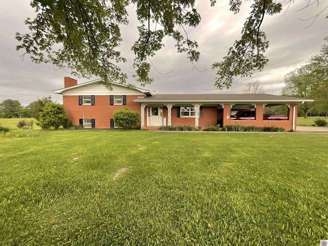 tri-level home featuring brick siding, a chimney, and a front lawn