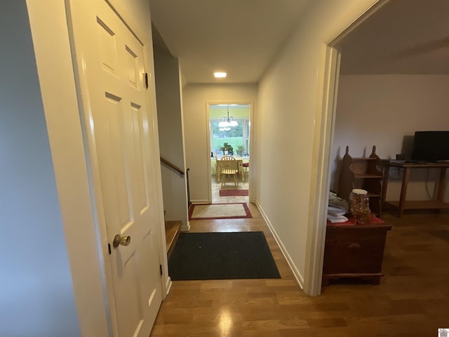 corridor featuring baseboards and wood finished floors