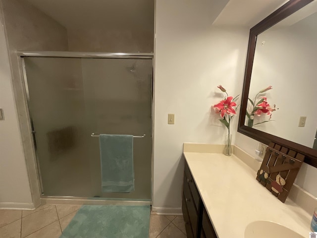 bathroom with tile patterned flooring, baseboards, vanity, and a shower stall