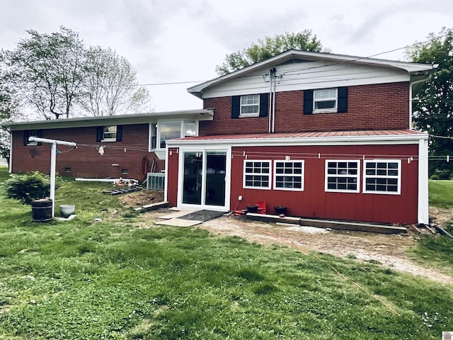 rear view of property featuring a yard and brick siding