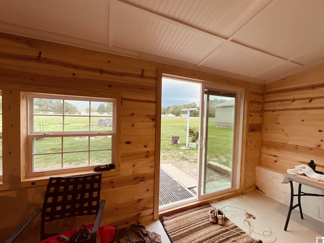 doorway to outside with wooden walls and vaulted ceiling