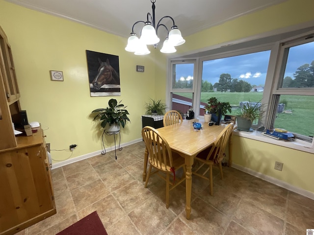 dining area with crown molding, baseboards, and an inviting chandelier