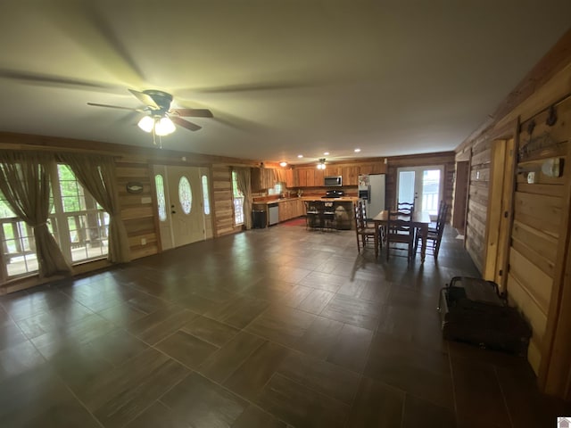 dining area with wooden walls and a ceiling fan