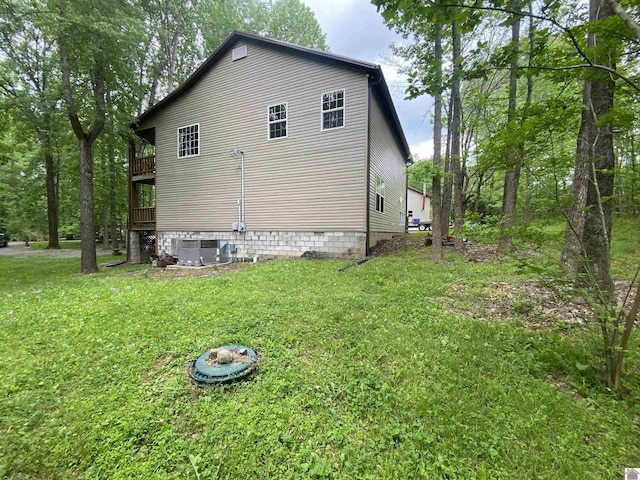 view of side of home with a lawn and central AC unit