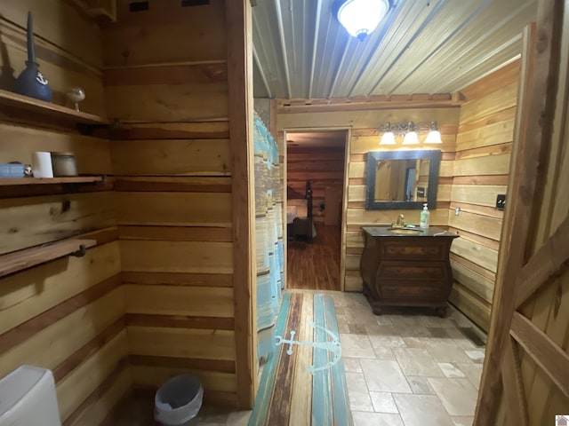 bathroom featuring vanity, wood ceiling, wooden walls, and toilet