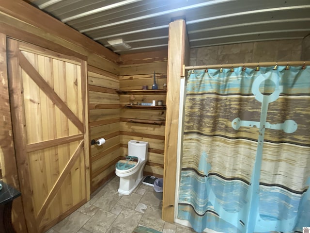 full bathroom with wooden walls, toilet, and a shower with shower curtain