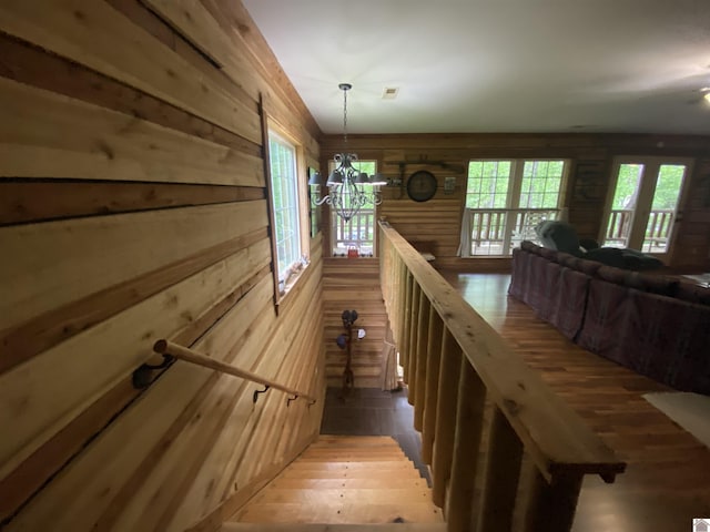 stairway with wood-type flooring and wood walls