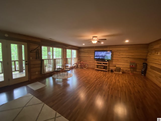 unfurnished living room with wooden walls, a ceiling fan, recessed lighting, and wood finished floors