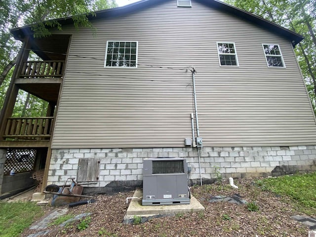 view of property exterior with central air condition unit and a balcony