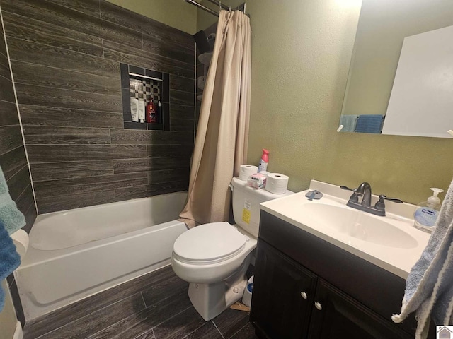 bathroom featuring wood finished floors, vanity, toilet, a textured wall, and shower / bathtub combination with curtain
