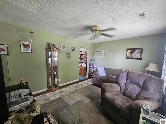 living area with visible vents, baseboards, ceiling fan, and a wall mounted AC