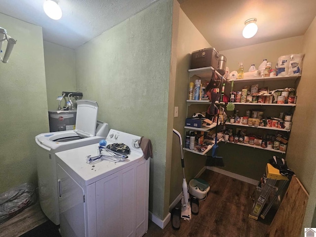 clothes washing area featuring water heater, laundry area, wood finished floors, and washing machine and clothes dryer