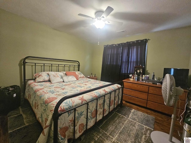 bedroom featuring ceiling fan, visible vents, and dark wood-type flooring