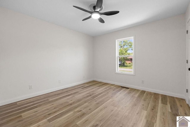 empty room featuring light wood-type flooring, a ceiling fan, and baseboards