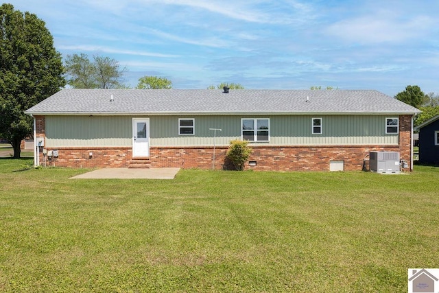 back of property with central AC unit, a patio area, brick siding, a yard, and entry steps