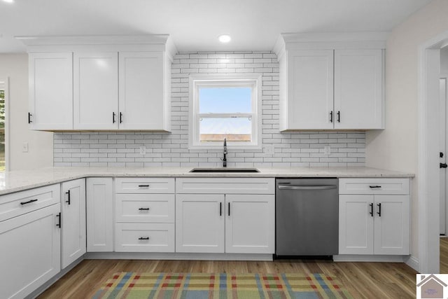 kitchen featuring stainless steel dishwasher, a wealth of natural light, a sink, and light wood-style flooring