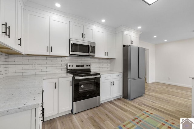 kitchen featuring baseboards, white cabinets, stainless steel appliances, and light wood-style flooring