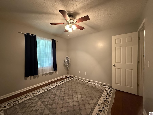 unfurnished room featuring baseboards, a ceiling fan, and a textured ceiling