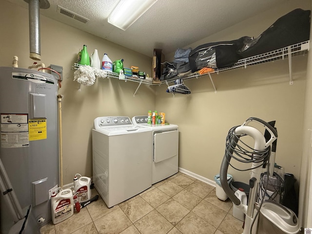 laundry room with light tile patterned flooring, laundry area, visible vents, washing machine and dryer, and electric water heater
