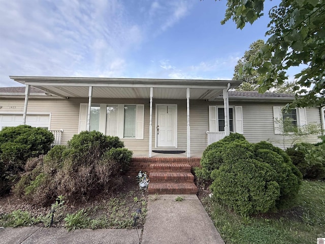 single story home with a porch and an attached garage