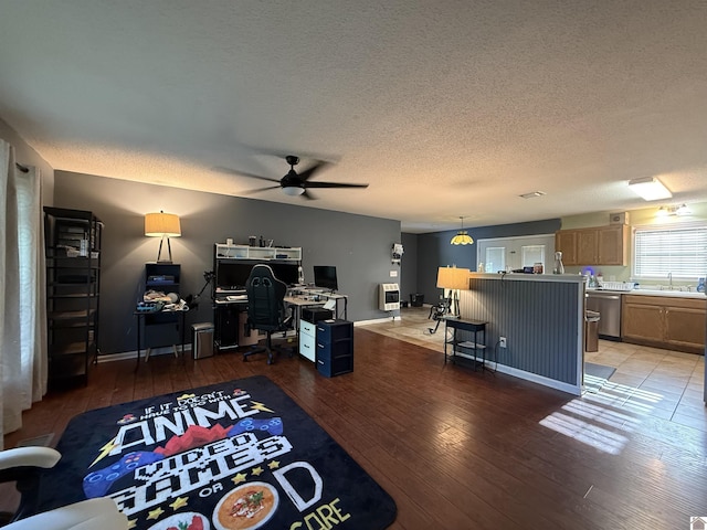 office with a sink, a textured ceiling, a ceiling fan, and light wood-style flooring