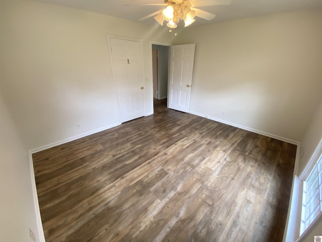 unfurnished bedroom with baseboards, ceiling fan, and dark wood finished floors