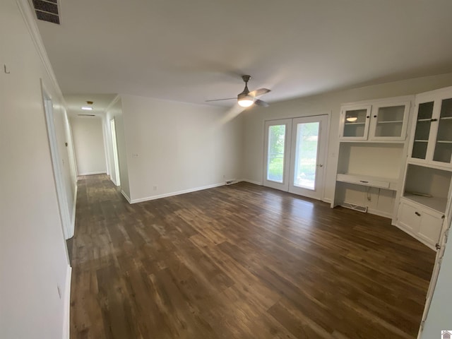 unfurnished living room featuring ceiling fan, visible vents, and dark wood finished floors