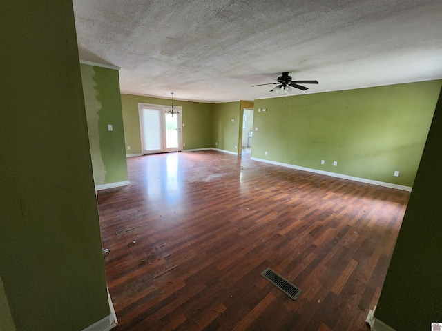 unfurnished room with visible vents, ceiling fan with notable chandelier, and wood finished floors