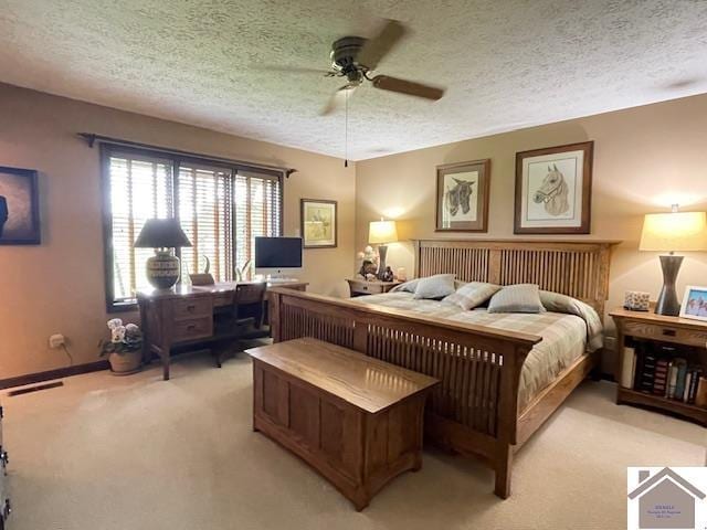 bedroom featuring a textured ceiling, light colored carpet, and ceiling fan